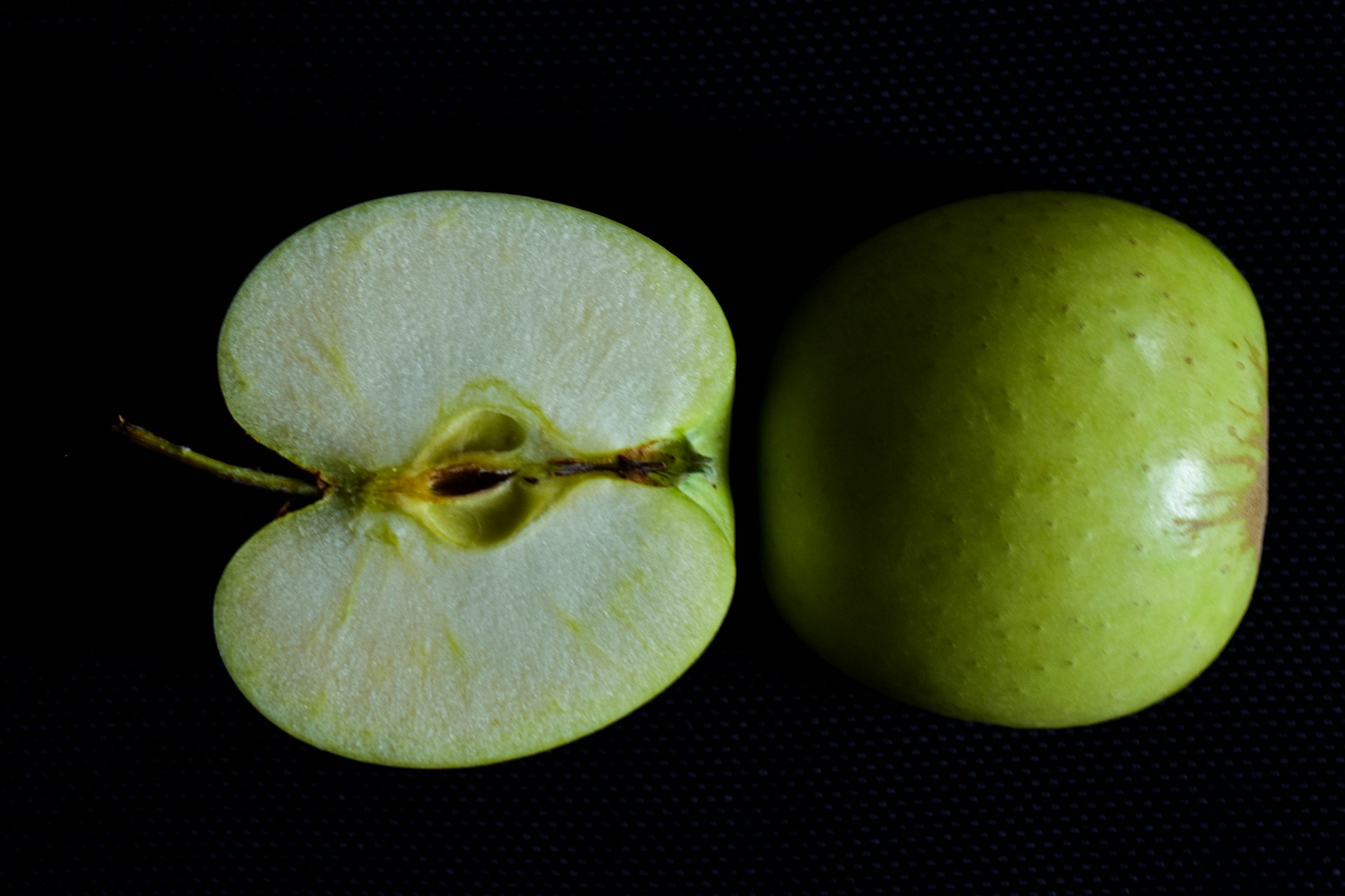 green round fruit on black background