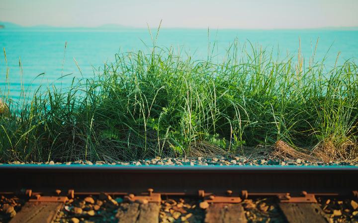 a view of the ocean from a train track